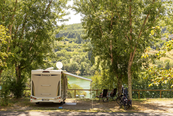 camping-car face au lac du causse, 2 campeurs sur des chaises longues